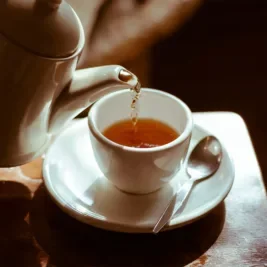 tea pot pouring tea into teacup