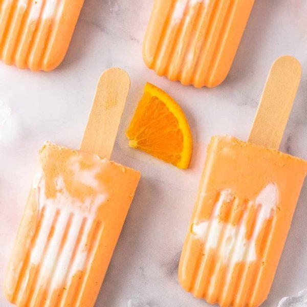 Orange Creamsicles on a marble countertop.