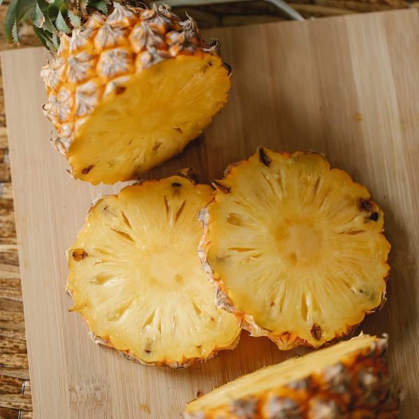 Fresh cut pineapple on a wood cutting board.