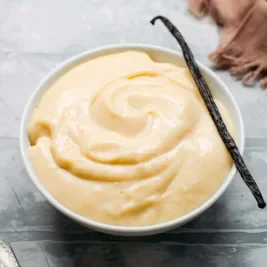 Bowl of creamy vanilla pudding with a vanilla bean.