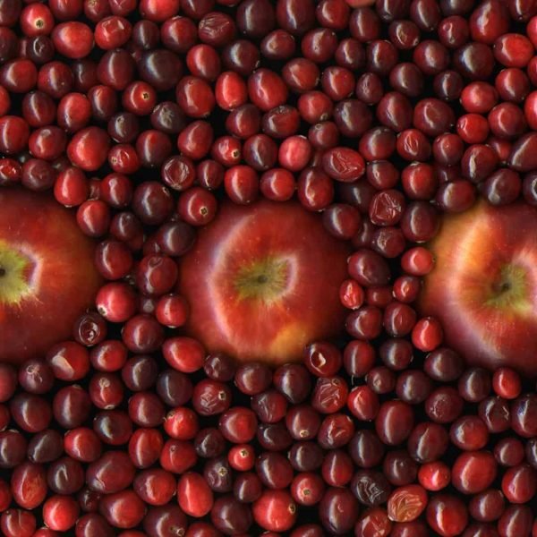 3 Apples sitting in a bed of cranberries.