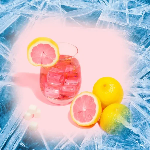 A jug of pink lemonade surrounded by ice.