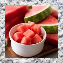 Cut up watermelon in a bowl, with a salt border.