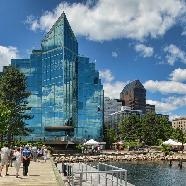 Tall mirrored building in Halifax, Nova Scotia. With people, who obey vape laws.